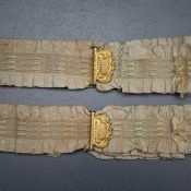 Ruffled elastic garters with gilt monogrammed adjusters, c. 1910s, USA. Photography by Tigz Rice Studios. From The Underpinnings Museum collection.