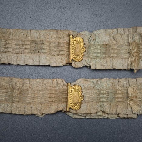 Ruffled elastic garters with gilt monogrammed adjusters, c. 1910s, USA. Photography by Tigz Rice Studios. From The Underpinnings Museum collection.