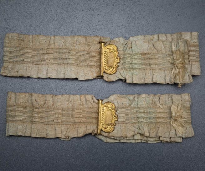 Ruffled elastic garters with gilt monogrammed adjusters, c. 1910s, USA. Photography by Tigz Rice Studios. From The Underpinnings Museum collection.