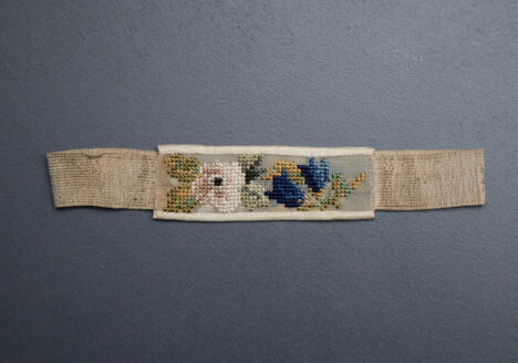 Cross stitch wedding garter, belonged to Mrs Clara Jane Wreford-Brown, 1864, Great Britain. From The Underpinnings Museum collection. Photography by Tigz Rice.