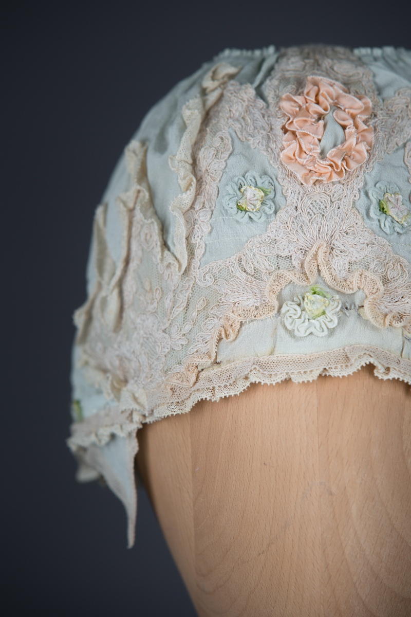 Pale blue silk boudoir cap with ribbonwork and lace, c. 1920s, GB. The Underpinnings Museum. Photo by Tigz Rice