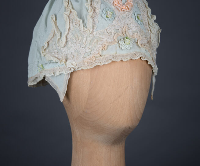 Pale blue silk boudoir cap with ribbonwork and lace, c. 1920s, GB. The Underpinnings Museum. Photo by Tigz Rice