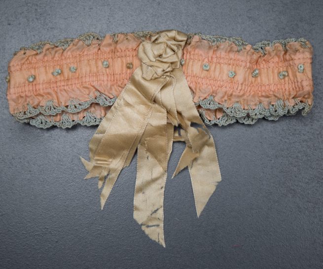 Pink Ribbon Garter With Blue Crochet Trim & Cream Rosette, c. 1920s, USA. The Underpinnings Museum. Photography by Tigz Rice