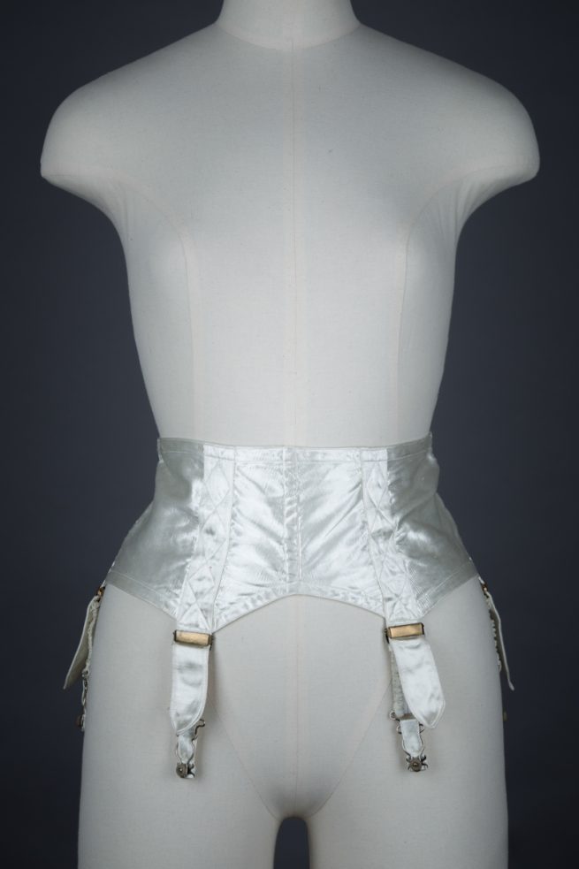 Ivory Quilted Satin Suspender Belt With Button Fastening, c. 1940s, Great Britain. The Underpinnings Museum. Photography by Tigz Rice