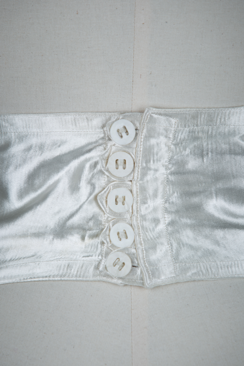 Ivory Quilted Satin Suspender Belt With Button Fastening, c. 1940s, Great Britain. The Underpinnings Museum. Photography by Tigz Rice