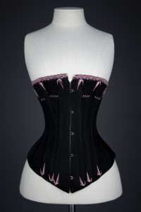 Black Cotton Corset With Spoon Busk, Pink Flossing Embroidery & Woven Trim, c. 1890-1900s, Great Britain. The Underpinnings Museum. Photography by Tigz Rice.