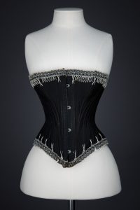 Black Cotton Sateen Corset With White Flossing & Woven Trim by P. N., C. late 1880s - early 1890s, USA. The Underpinnings Museum. Photography by Karolina Laskowska