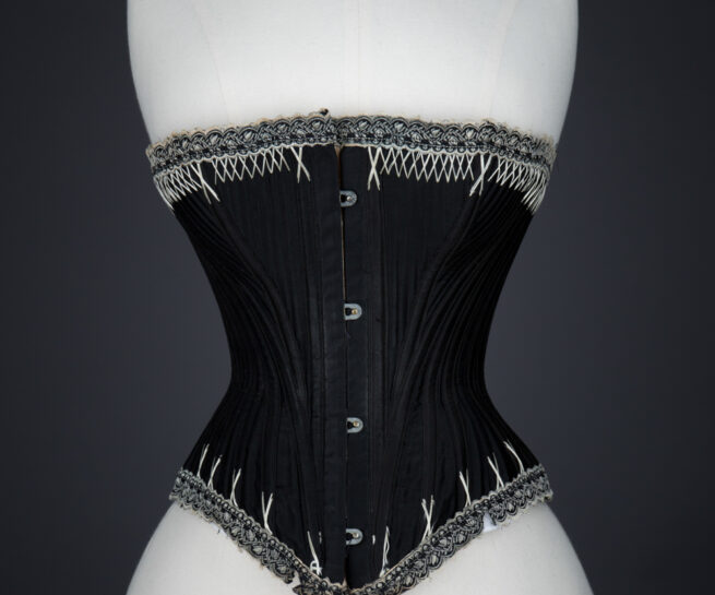 Black Cotton Sateen Corset With White Flossing & Woven Trim by P. N., C. late 1880s - early 1890s, USA. The Underpinnings Museum. Photography by Karolina Laskowska