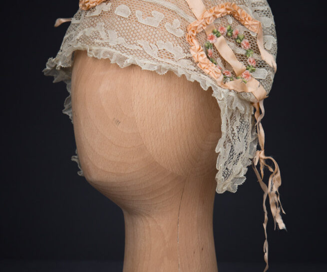 Cream Machine Lace Boudoir Cap With Silk Ribbonwork & Wired Ear Covers, c. 1920s, Great Britain. The Underpinnings Museum. Photography by Tigz Rice