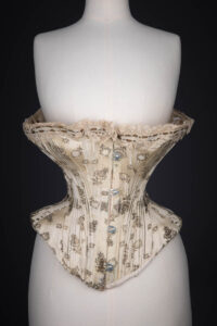 Metal & Silk Brocade Corset With Ribbon Slot Lace Trim, c. 1900s. The Underpinnings Museum. Photography by Tigz Rice