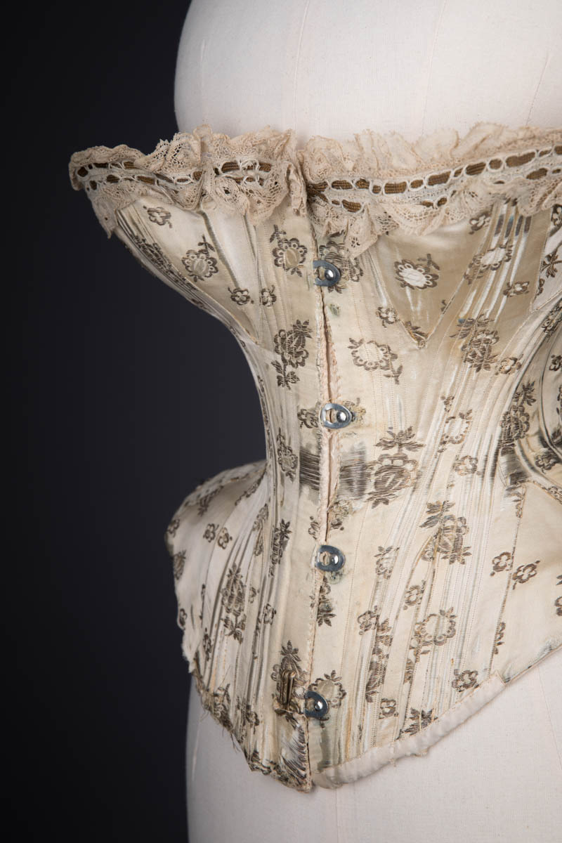 Metal & Silk Brocade Corset With Ribbon Slot Lace Trim, c. 1900s. The Underpinnings Museum. Photography by Tigz Rice