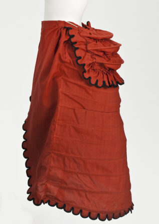 Woman's Cage Crinolette Petticoat. Date: 1872-1875. Origin: England. Fabric: Wool plain weave, cotton plain weave, cotton-braid-covered steel, cotton twill tape, and wool-braid trim ​​From the collection of the Los Angeles County Museum of Art. Museum number: M.2007.211.388