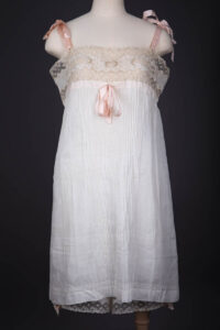 Pleated Cotton Slip With Moon Embroidery, Lace Trim & Silk Ribbon Straps, c. 1910s, Great Britain. The Underpinnings Museum. Photography by Tigz Rice.