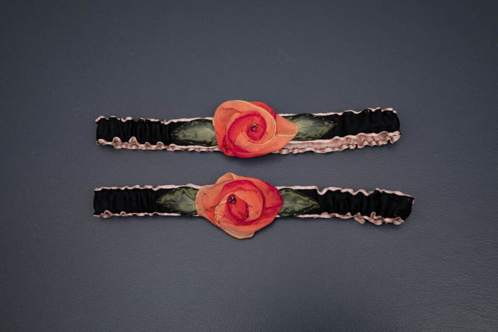 Black Ribbon Garters With Ribbonwork Roses By Piper Ewan, c. late 2010s, USA. The Underpinnings Museum. Photography by Tigz Rice.