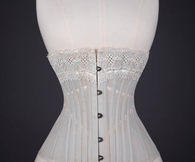 Grey Herringbone Coutil Corset With Ribbon Slot Lace Trim & Woven Ribbon Embellishment By Corset Cigno, c. 1900s, Italy. The Underpinnings Museum. Photography by Tigz Rice.