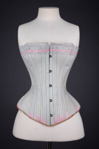 Grey Cotton Corset With Contrast Pink Flossing Embroidery And Lace Ribbon Slot Trim By Fitu Corsets, c. 1900s, Great Britain. The Underpinnings Museum. Photography by Tigz Rice.