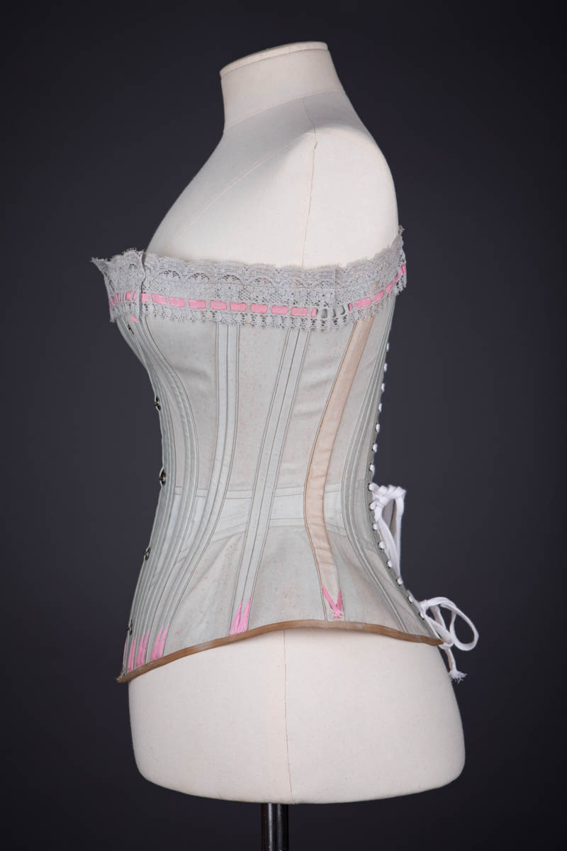 Grey Cotton Corset With Contrast Pink Flossing Embroidery And Lace Ribbon Slot Trim By Fitu Corsets, c. 1900s, Great Britain. The Underpinnings Museum. Photography by Tigz Rice.