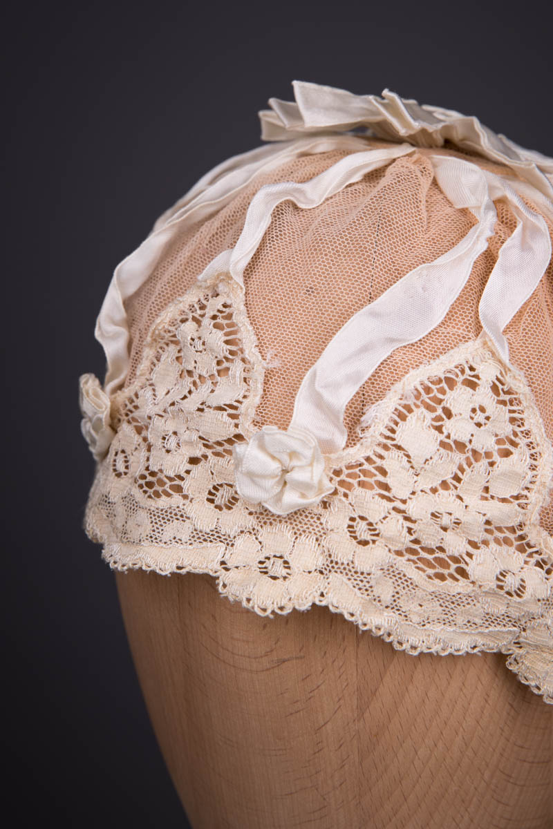 Beige Cotton Tulle Boudoir Cap With Ribbon & Machine Lace Trim, c. 1920s. The Underpinnings Museum. Photography by Tigz Rice.